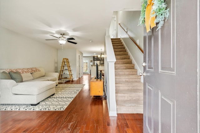 living room with hardwood / wood-style flooring and ceiling fan with notable chandelier