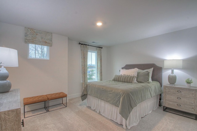 bedroom with multiple windows and light carpet