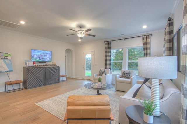 living room featuring light wood-type flooring, ornamental molding, and ceiling fan