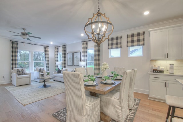 dining area featuring ornamental molding, ceiling fan with notable chandelier, and light hardwood / wood-style flooring