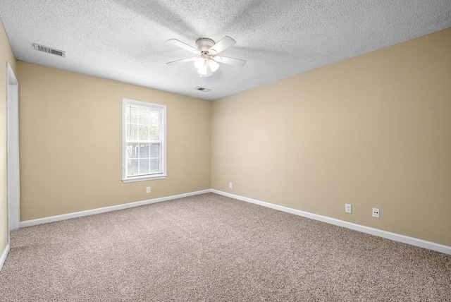 carpeted spare room with a textured ceiling and ceiling fan