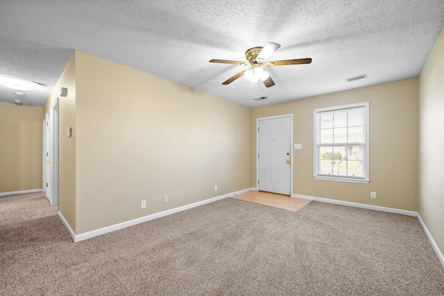 empty room with carpet flooring, a textured ceiling, and ceiling fan