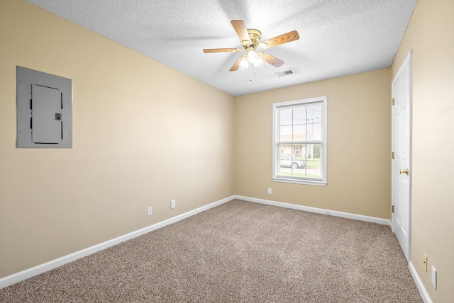 carpeted spare room featuring a textured ceiling, electric panel, and ceiling fan