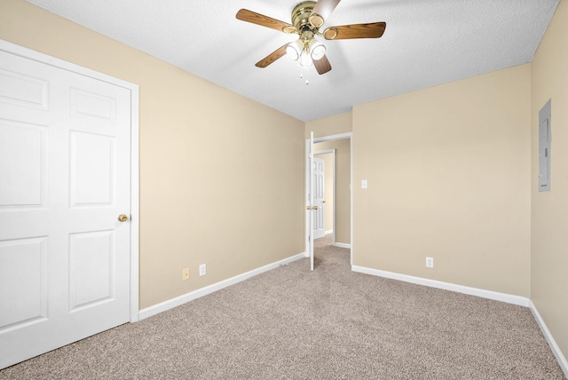 carpeted empty room with ceiling fan, electric panel, and a textured ceiling