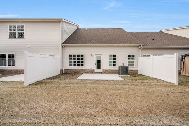 rear view of house featuring a patio area, a lawn, and central air condition unit