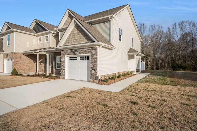 view of front of property with stone siding, concrete driveway, roof with shingles, and a front yard