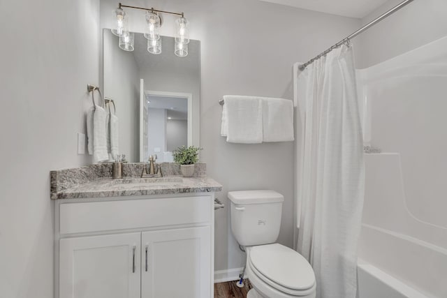 bathroom featuring toilet, baseboards, shower / tub combo with curtain, and vanity