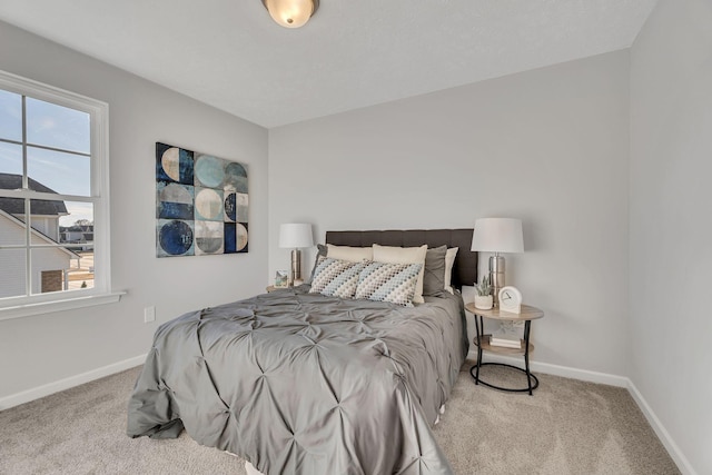 bedroom featuring light carpet and baseboards