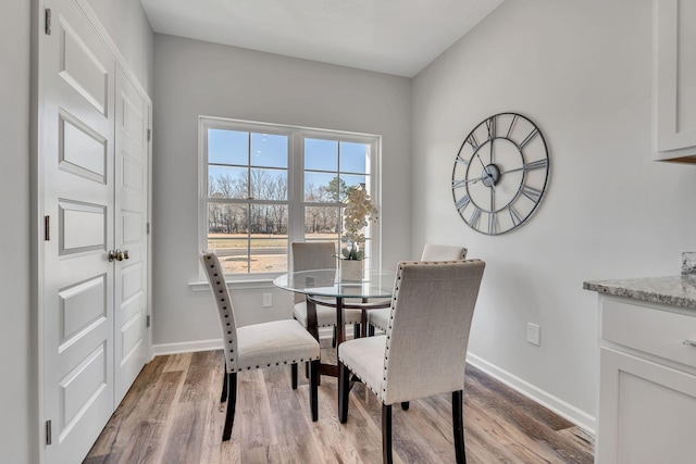 dining room featuring light wood-style flooring and baseboards