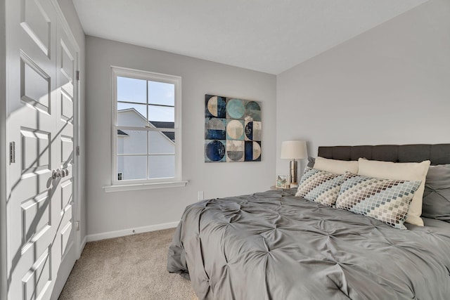 bedroom featuring light carpet and baseboards