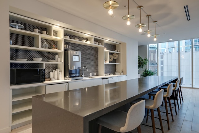 515 Church St Unit 3208, Nashville, TN 37219 - kitchen with a center island, pendant lighting, white cabinets, and light wood-type flooring