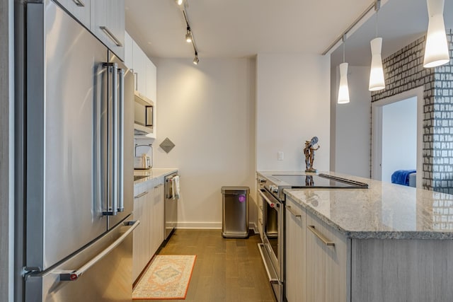 515 Church St Unit 3208, Nashville, TN 37219 - kitchen featuring rail lighting, hanging light fixtures, high quality appliances, dark hardwood / wood-style flooring, and light stone countertops