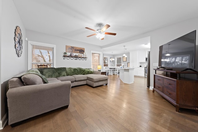 living room with ceiling fan and light hardwood / wood-style flooring