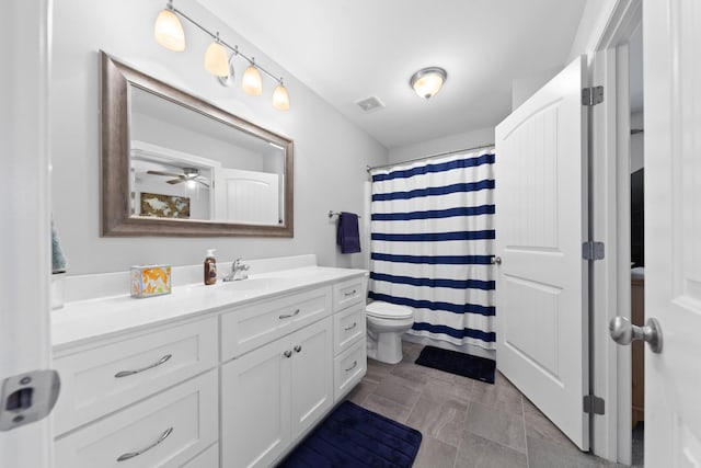 bathroom with walk in shower, vanity, and toilet