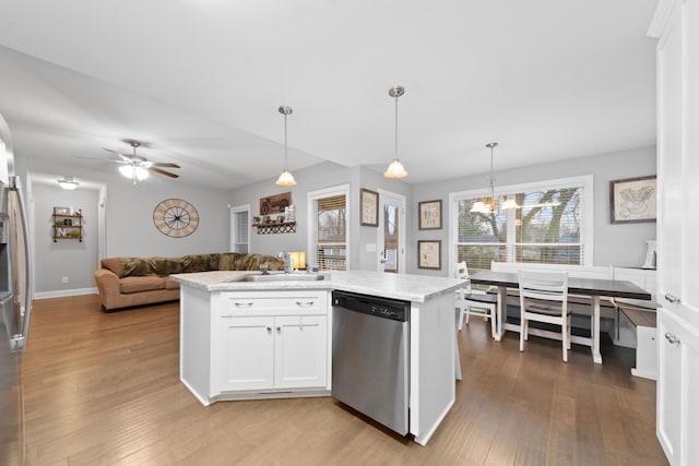 kitchen with white cabinets, sink, hanging light fixtures, and dishwasher