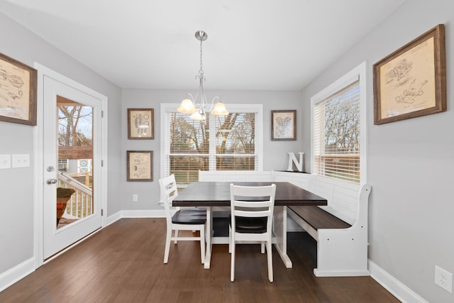 dining area with dark wood-type flooring and a chandelier