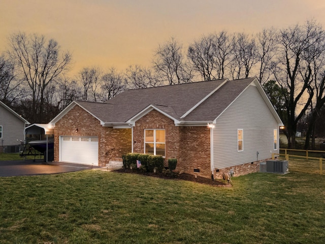 ranch-style home featuring a garage, central AC unit, and a lawn