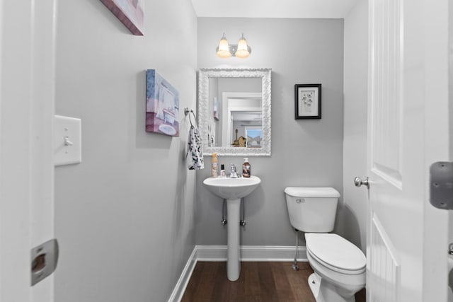 bathroom with hardwood / wood-style flooring and toilet