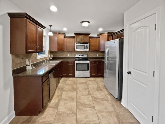 kitchen with appliances with stainless steel finishes, sink, backsplash, hanging light fixtures, and light tile patterned floors