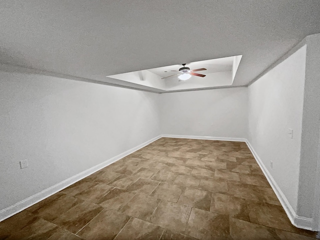 unfurnished room featuring ceiling fan and a tray ceiling