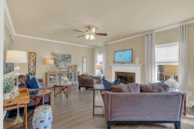 living room featuring a brick fireplace, crown molding, hardwood / wood-style floors, and ceiling fan