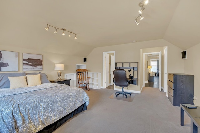 bedroom featuring vaulted ceiling, rail lighting, and carpet flooring