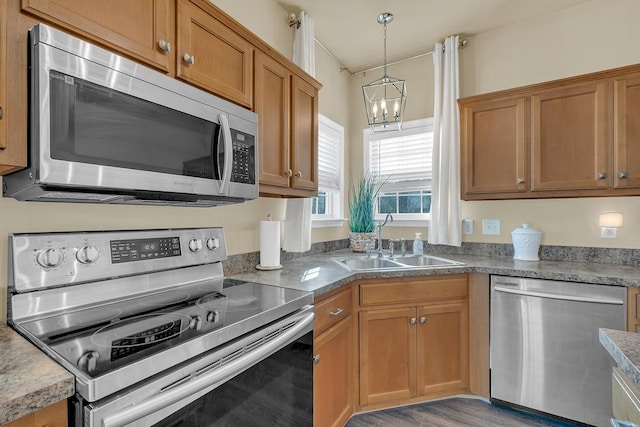 kitchen with a notable chandelier, sink, decorative light fixtures, and stainless steel appliances