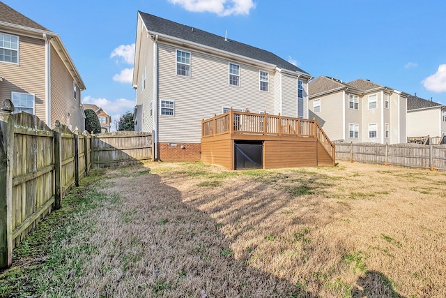 back of property with a wooden deck and a lawn