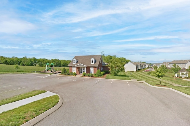 view of front of house featuring a front lawn and a playground