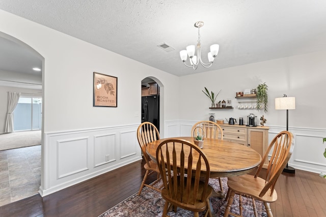 dining room featuring dark hardwood / wood-style floors, a chandelier, and a textured ceiling