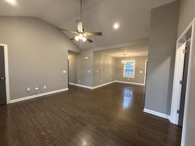 empty room with dark hardwood / wood-style floors, ceiling fan with notable chandelier, and high vaulted ceiling