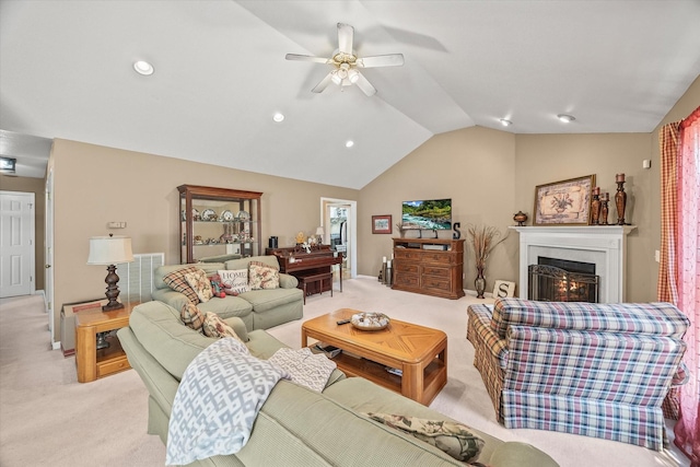 living room featuring ceiling fan, vaulted ceiling, and light carpet