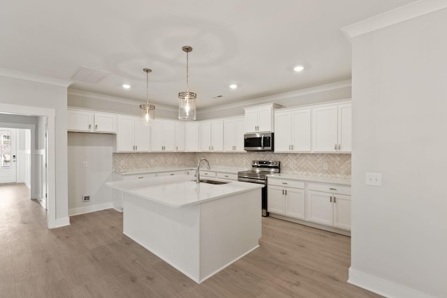 kitchen with sink, decorative light fixtures, stainless steel appliances, a kitchen island with sink, and white cabinets