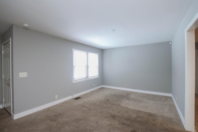 carpeted empty room featuring visible vents and baseboards