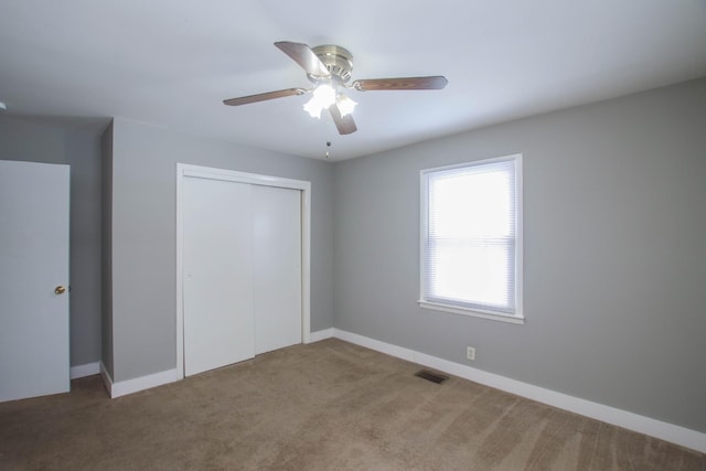 unfurnished bedroom with carpet floors, baseboards, visible vents, and a closet