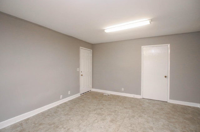 unfurnished room with baseboards