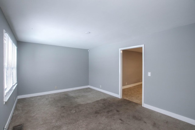 spare room with baseboards, visible vents, and carpet flooring