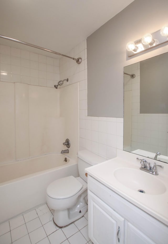 full bathroom with tile patterned flooring, toilet, vanity, tile walls, and tub / shower combination