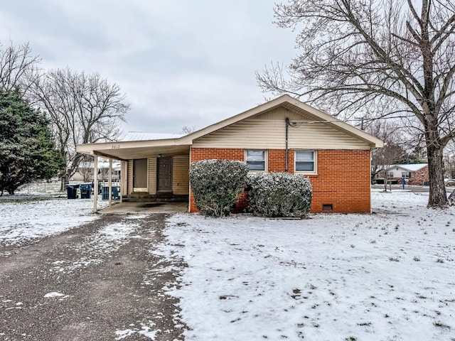 view of front facade with a carport, crawl space, and brick siding