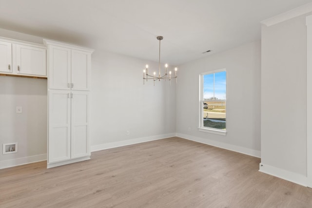 unfurnished dining area with a notable chandelier and light hardwood / wood-style floors