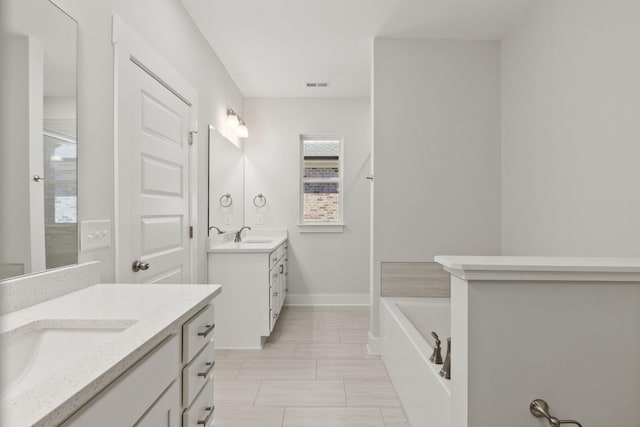 bathroom with vanity and a tub