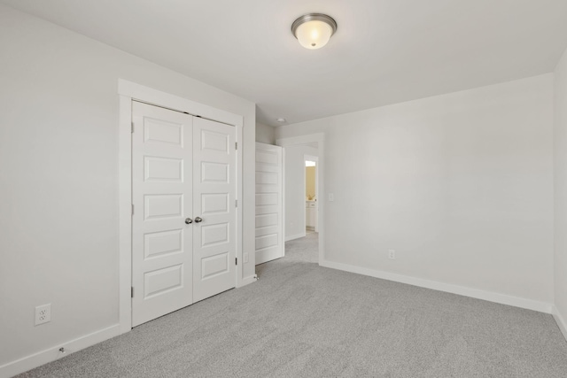 unfurnished bedroom featuring a closet and light carpet