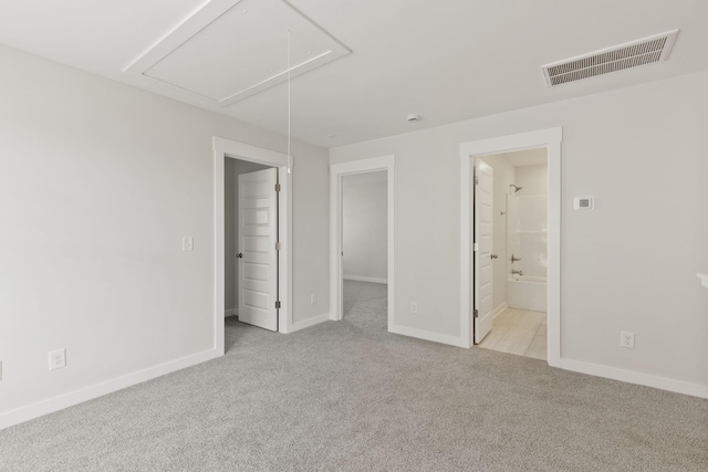 unfurnished bedroom featuring connected bathroom, a spacious closet, and light colored carpet