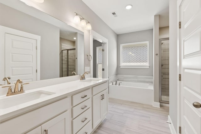 bathroom featuring vanity and shower with separate bathtub