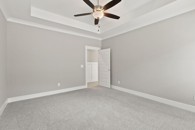 spare room with ceiling fan, ornamental molding, carpet flooring, and a raised ceiling