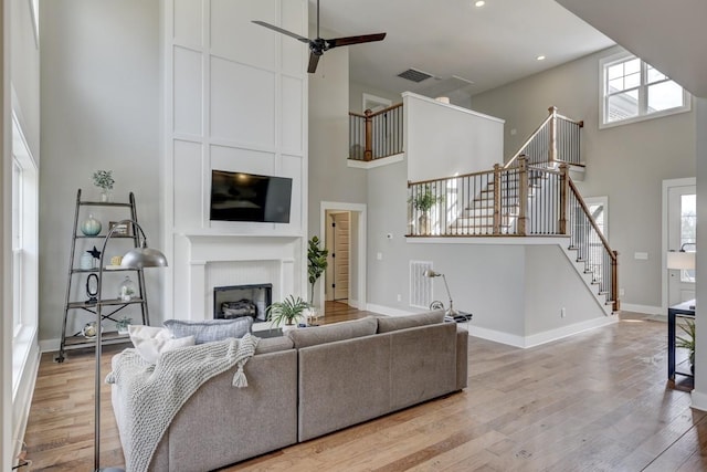 living room featuring a large fireplace, plenty of natural light, and light hardwood / wood-style floors