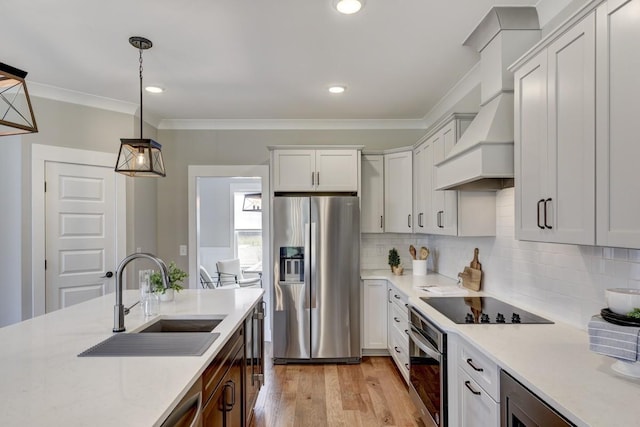 kitchen featuring pendant lighting, sink, appliances with stainless steel finishes, white cabinets, and custom exhaust hood