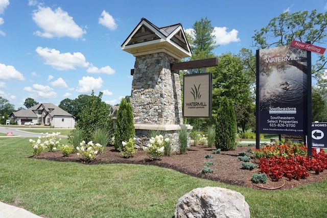 community / neighborhood sign featuring a lawn