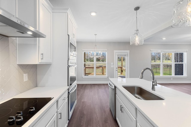 kitchen with pendant lighting, sink, appliances with stainless steel finishes, backsplash, and white cabinets