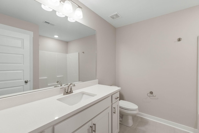 bathroom featuring vanity, tile patterned flooring, toilet, and a shower